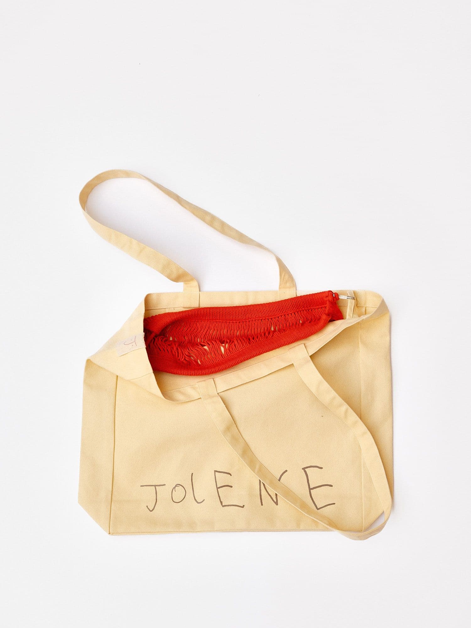 The Jolene bakery tote bag with the red net pocket inside it pictured on a white background