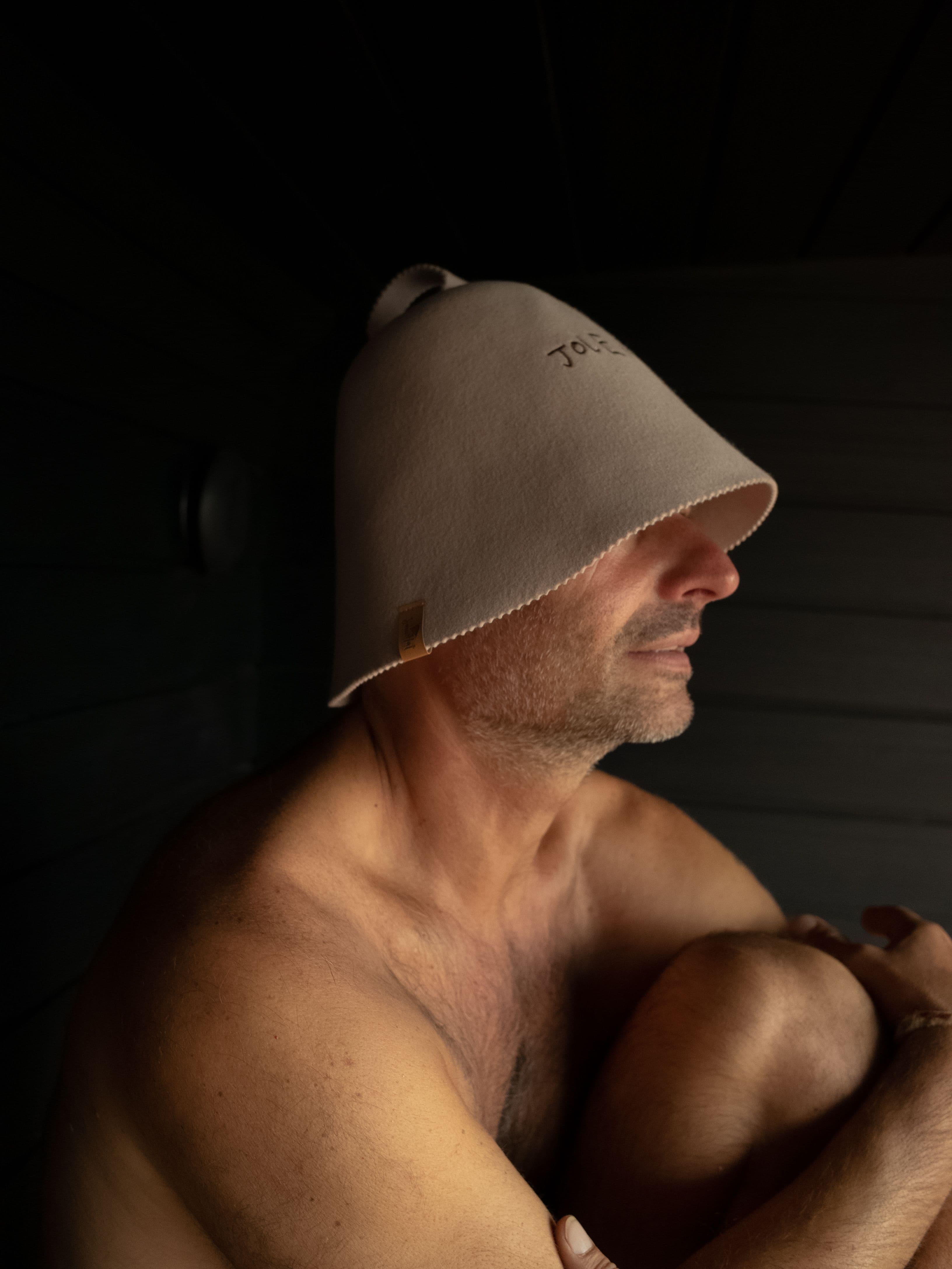 The Jolene sauna hat in stone photographed on a model in the Kiln Sauna down in Cornwall