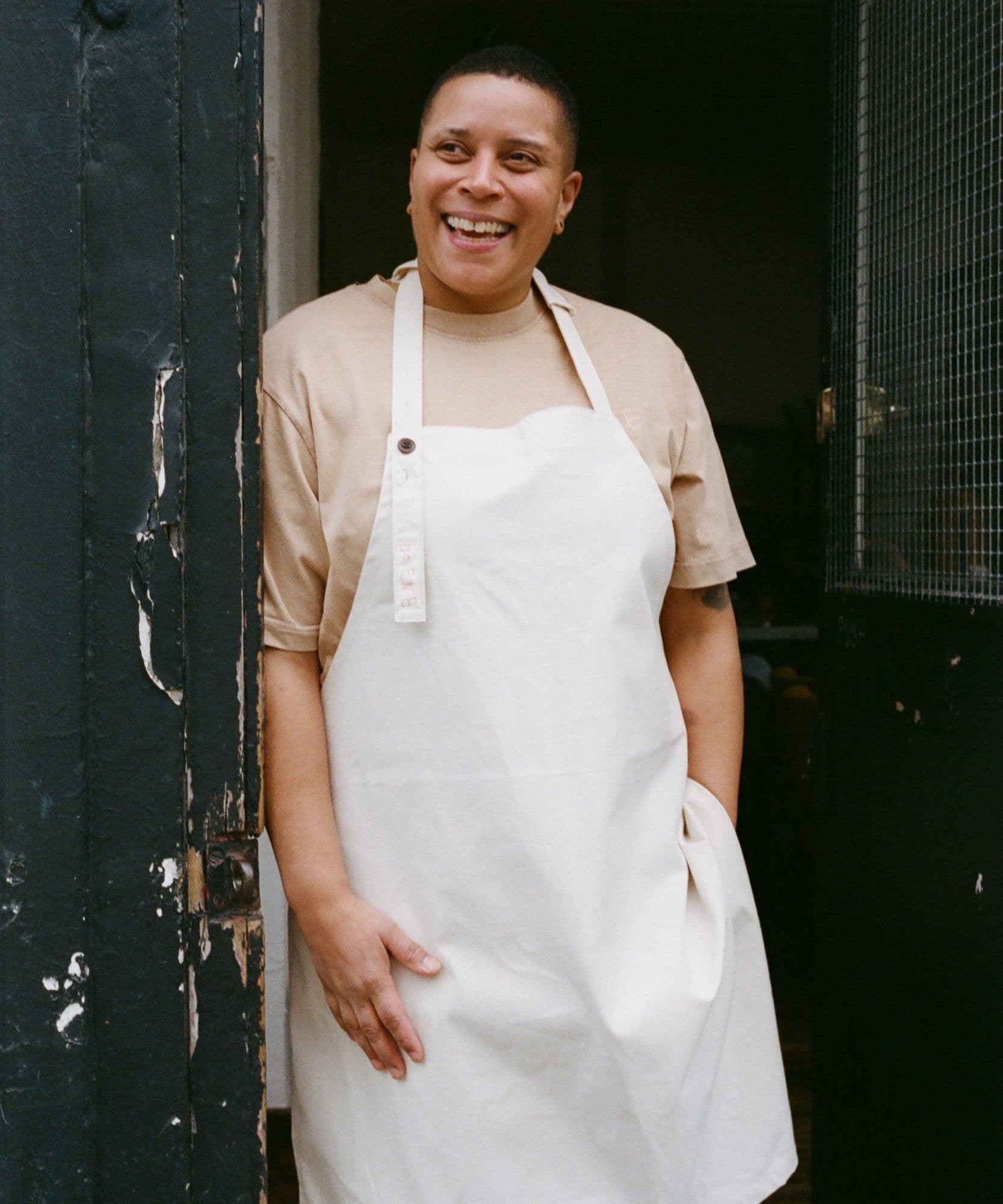 The Jolene Bakery house apron pictured here in the stone colour worn by one of our lovely team