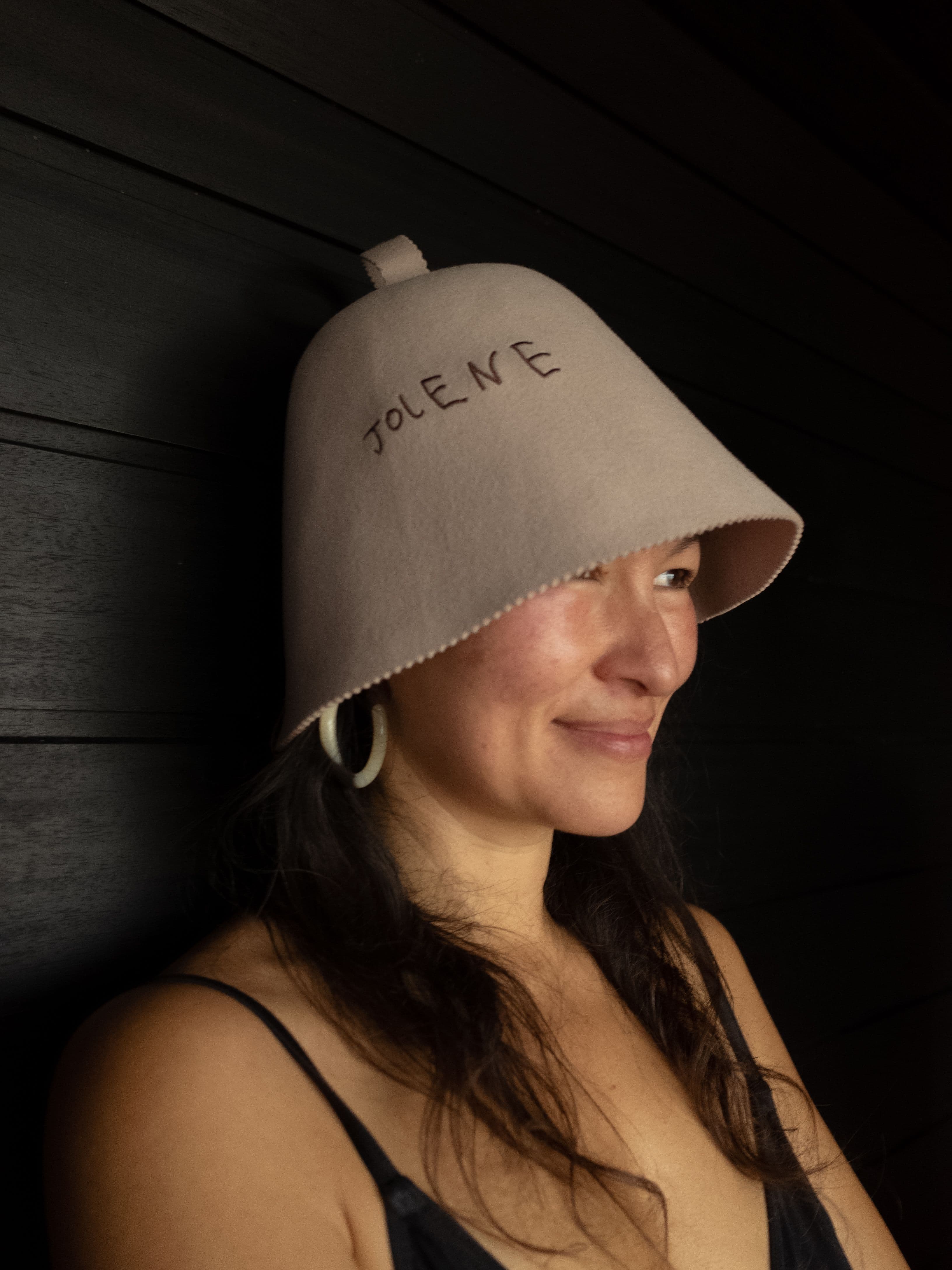 The Jolene sauna hat in stone photographed on a model in the Kiln Sauna down in Cornwall