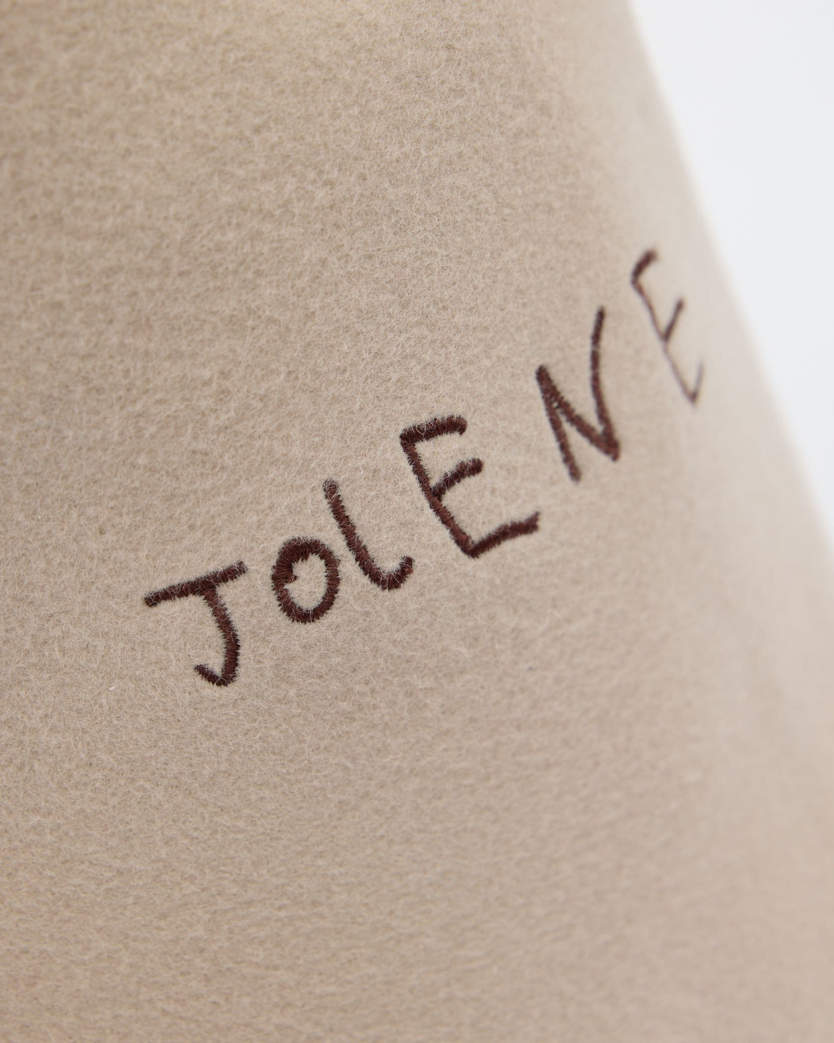 The Jolene Bakery sauna hat logo in brown shown on a white background
