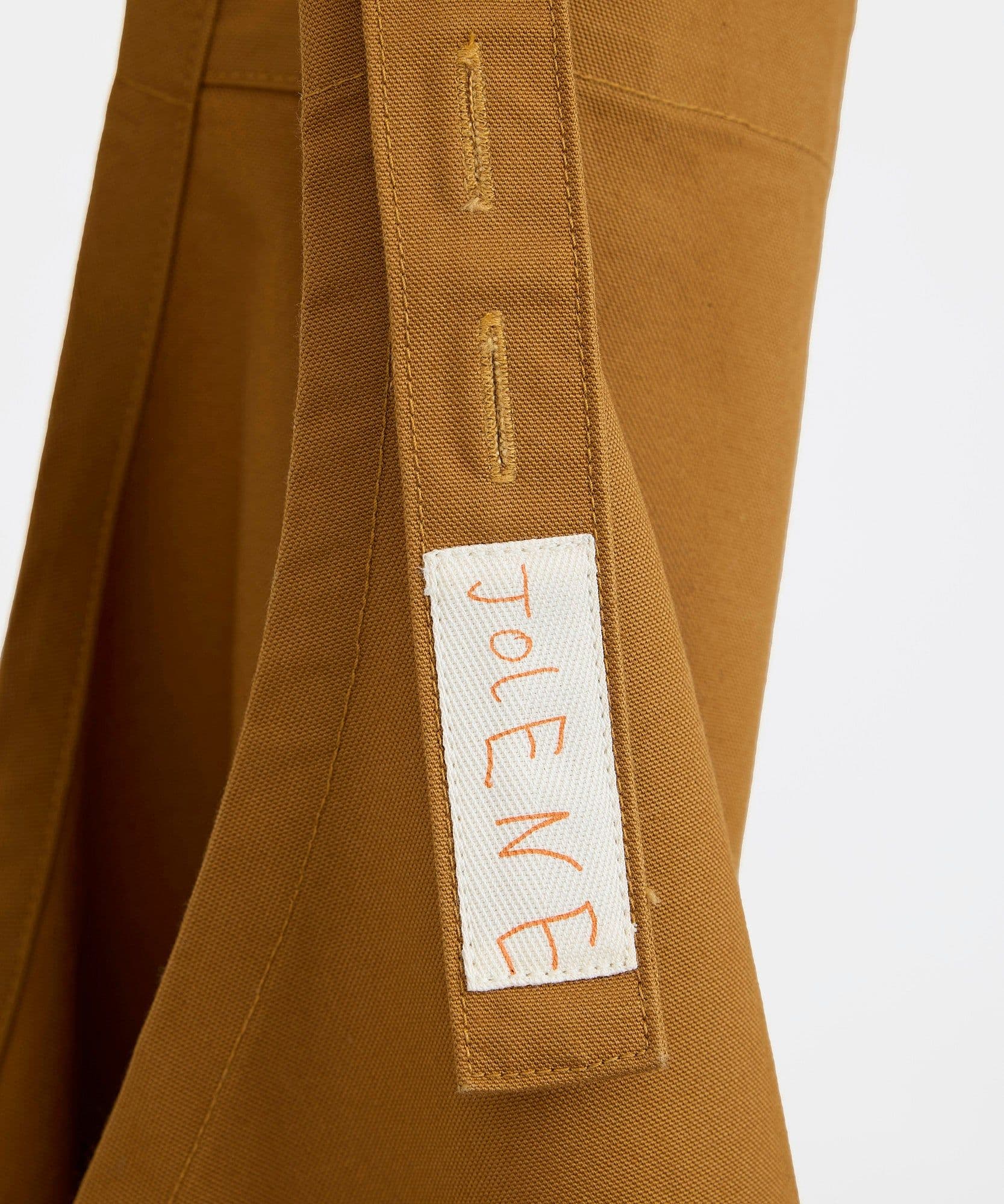 The label and branding of the Jolene Bakery house apron in caramel colour