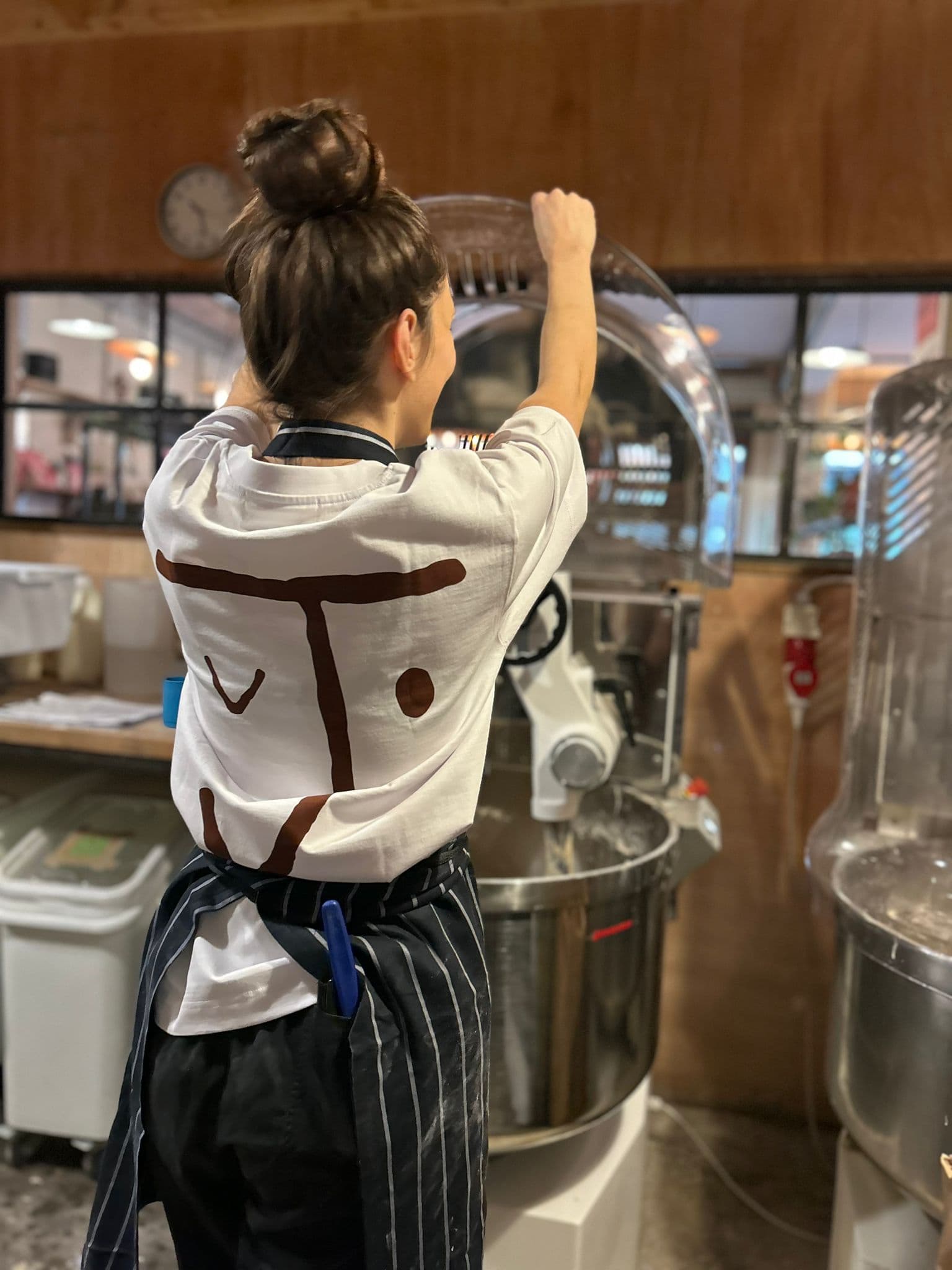 The Jolene bakery J face short sleeve t shirt being worn by one of our team in the bakery kitchen making cakes