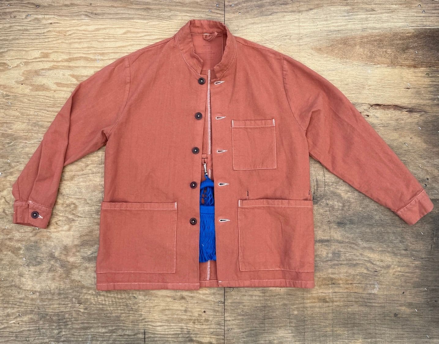 A product image of the Jolene pink workwear Jacket lying flat on a wooden surface
