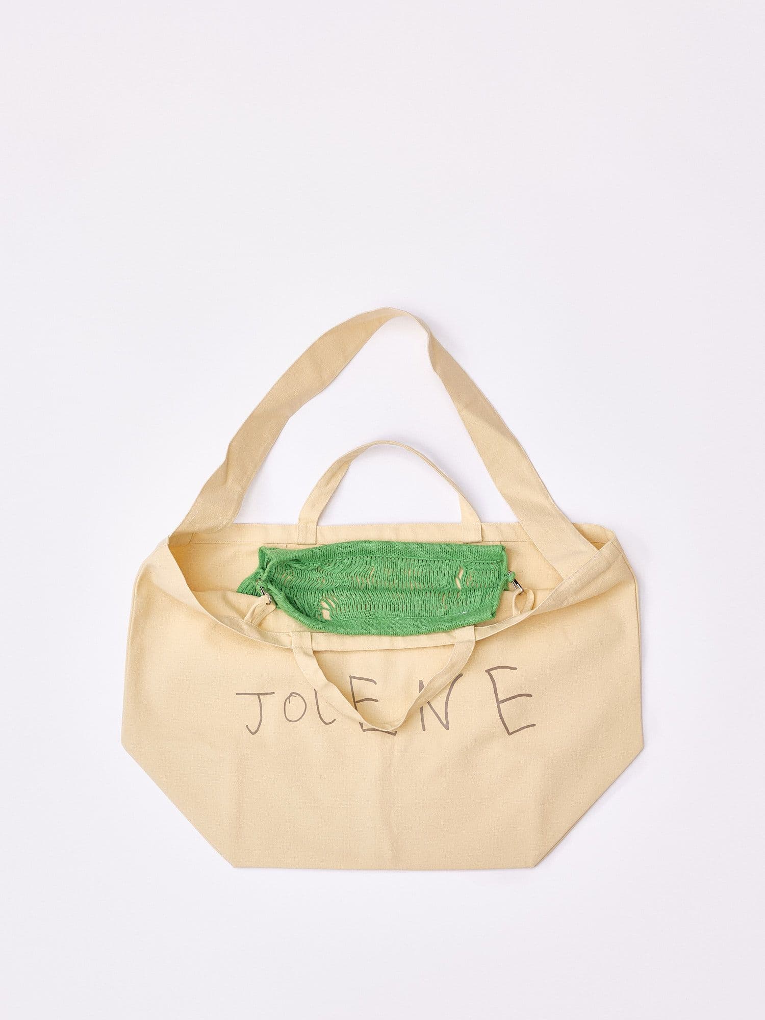The Jolene bakery tote bag with the green net pocket inside it pictured on a white background
