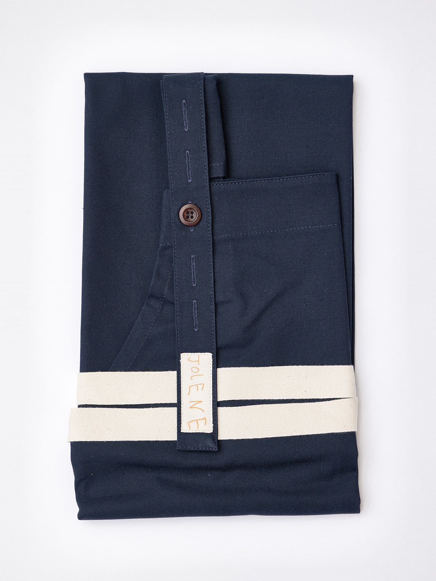 The Jolene Bakery house apron pictured here in the navy colour showing the apron folded up