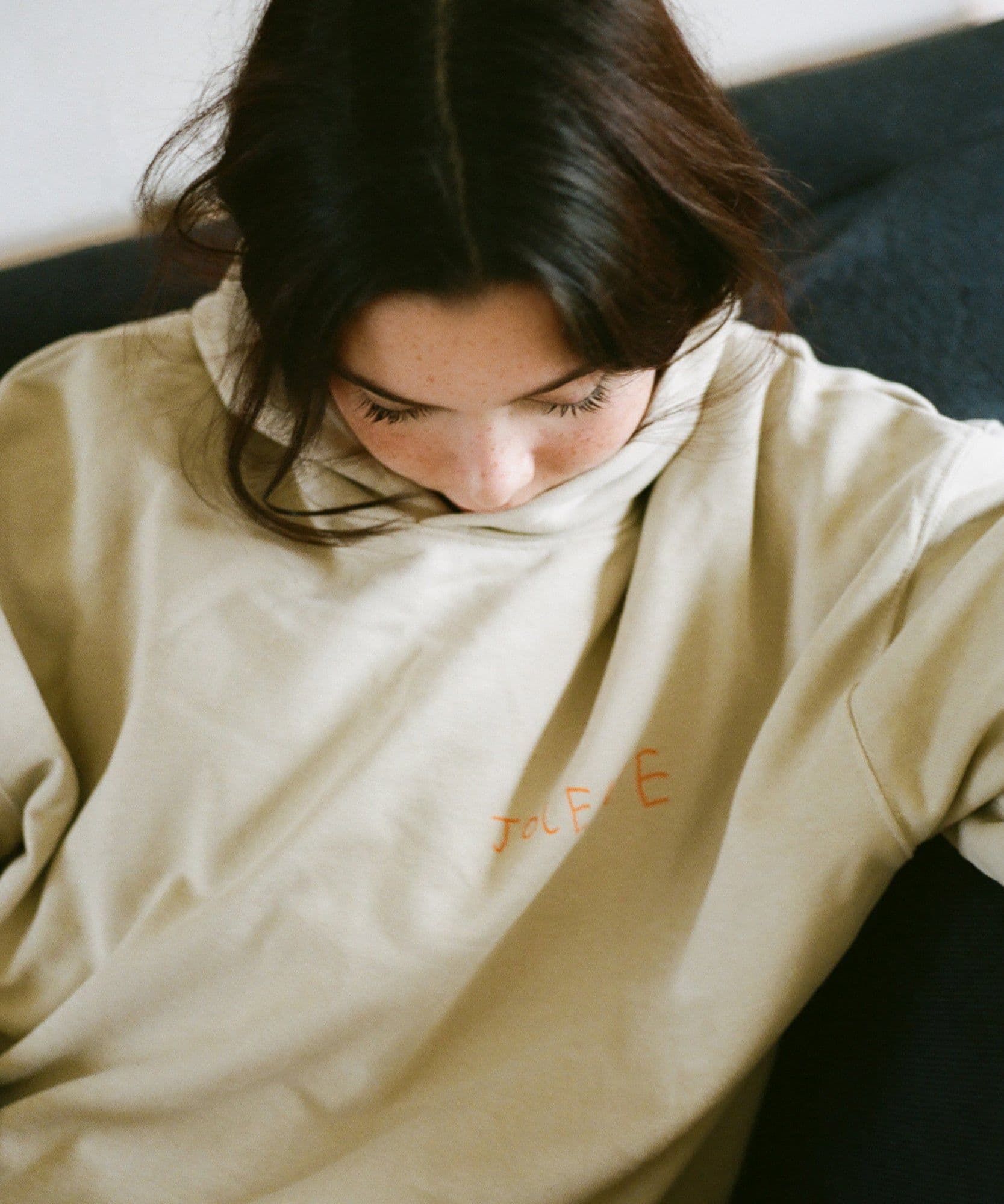 A model wearing the Jolene bakery J face hoodie in stone