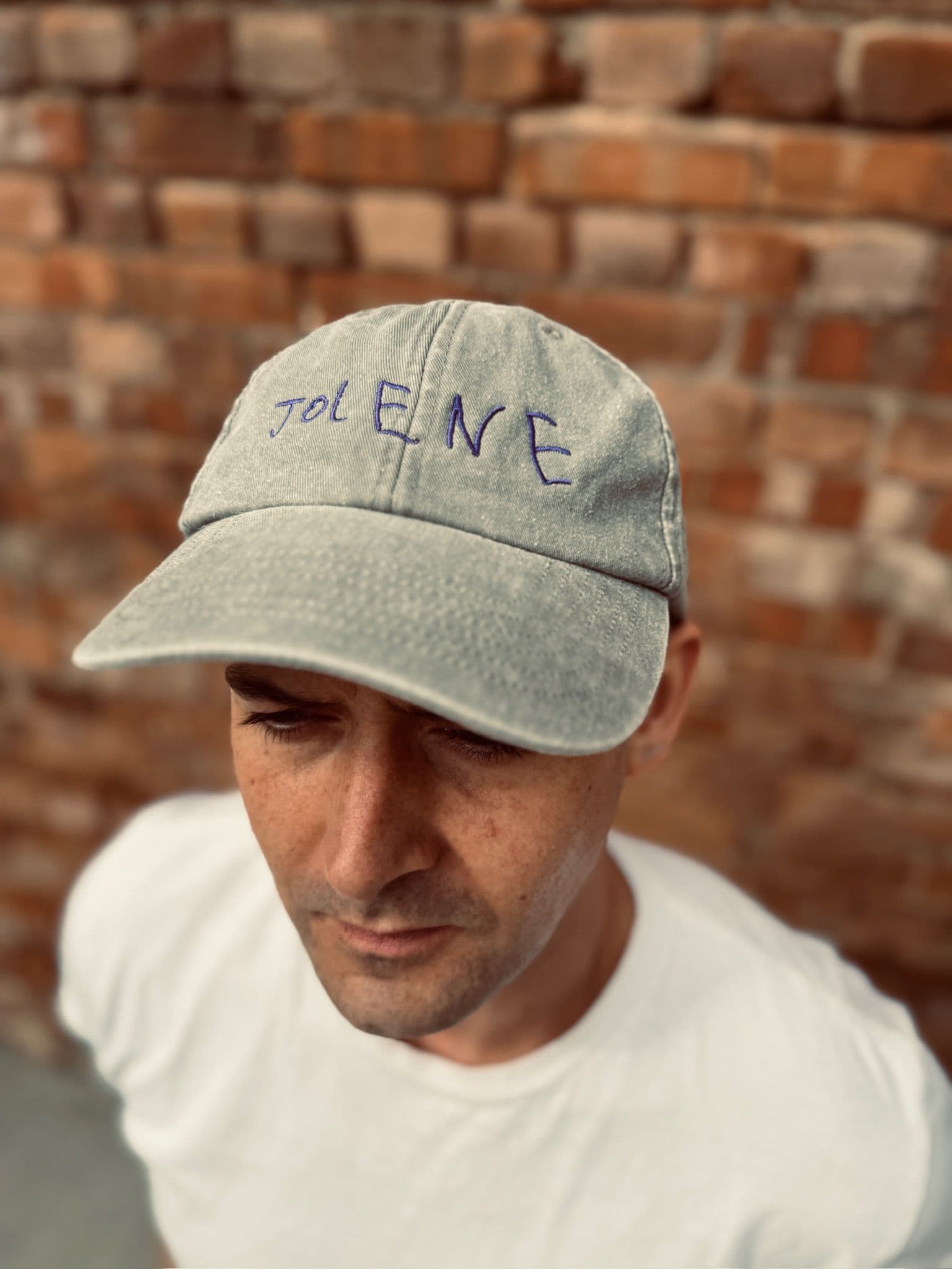 The Jolene house cap in gray with embroidered Jolene logo pictured on a model's head