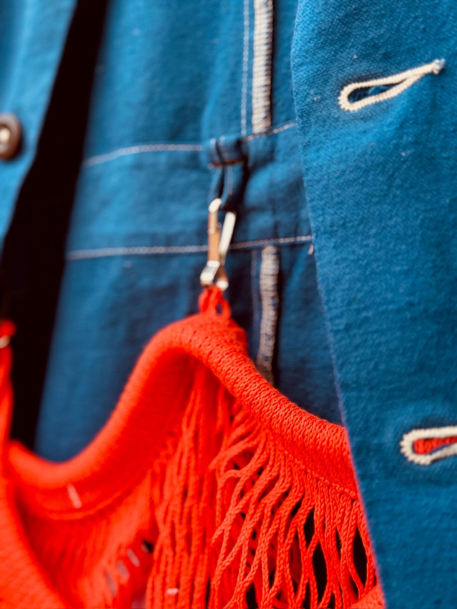 A detail image of the red net poacher pocket clipped to the inside of the Jolene blue jacket